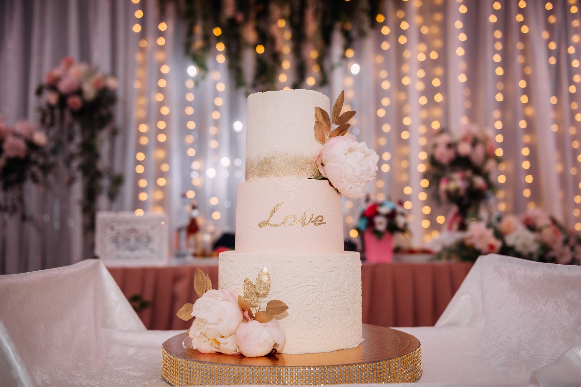 An original high wedding cake decorated with flowers and leaves 3813.